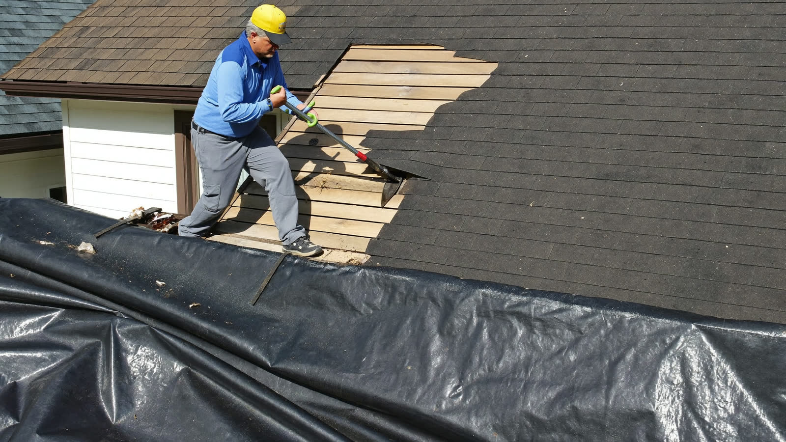 Crew tearing off old shingles during a one-day roof replacement